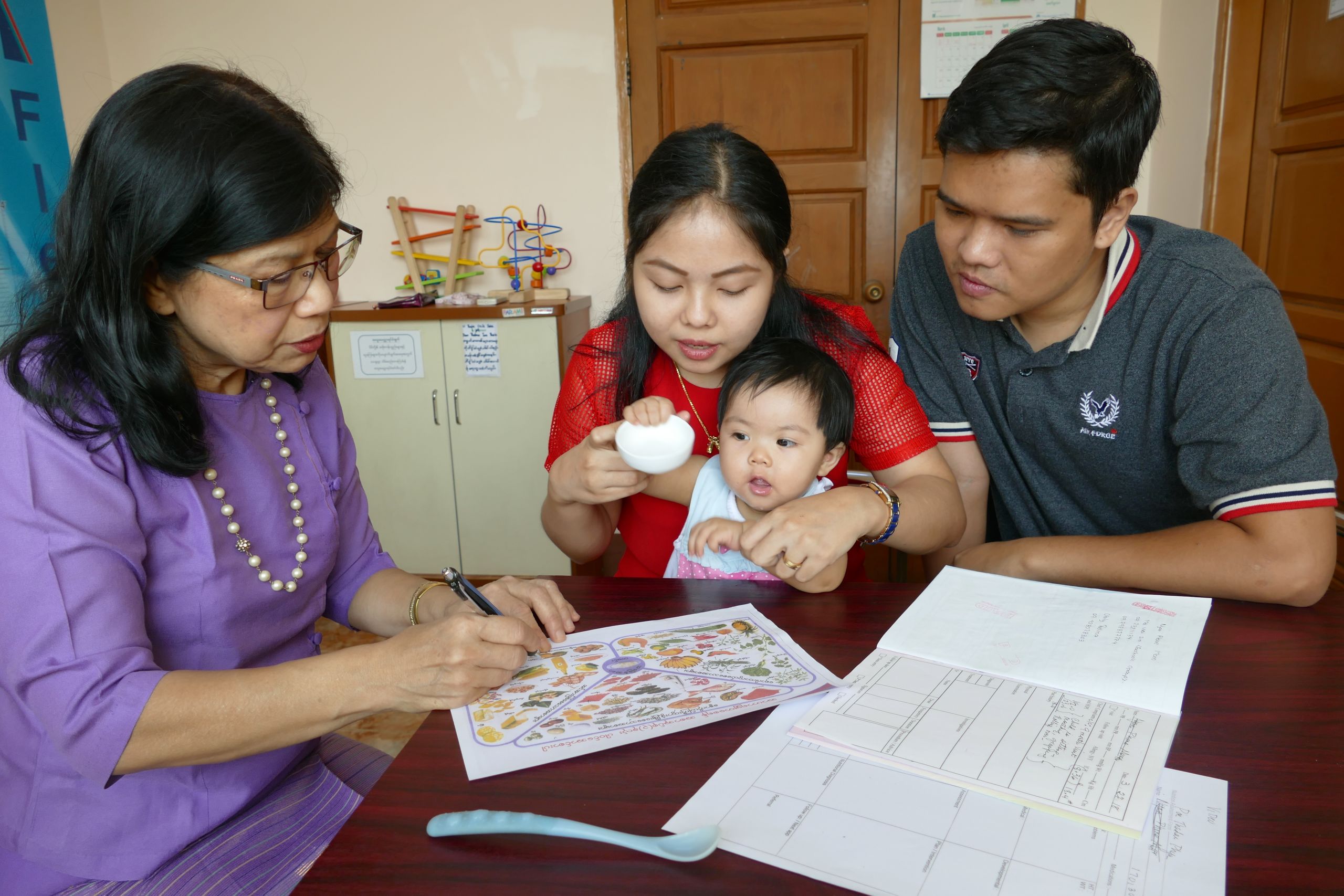 Parami General Hospital in Yangon. Nutritionist Thelma Tun Thein talks to a family about introducing diverse complementary foods for their 9-month old daughter.